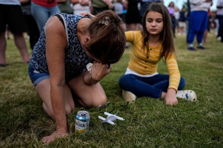 Brandy Rickaba and her daughter Emilie pray during a candlelight vigil for the slain students and teachers at Apalachee High School, Wednesday, Sept. 4, 2024, in Winder, Ga.