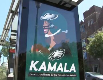 sign with Kamala Harris wearing an Eagles uninform