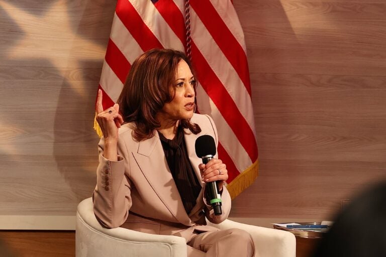 Kamala Harris sitting while holding a microphone