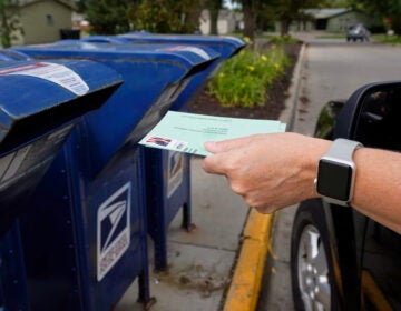 A ballot being dropped off in a mailbox