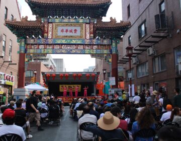 attendees watch a performance under the Chinatown Arch