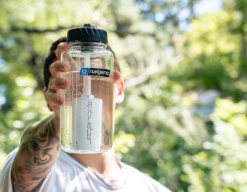 A person holds a Nalgene water bottle