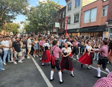 a crowd looks at dancers in the street