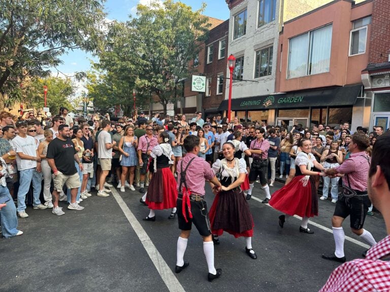 a crowd looks at dancers in the street