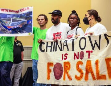 People holding up a sign that says 'Chinatown is not for sale'