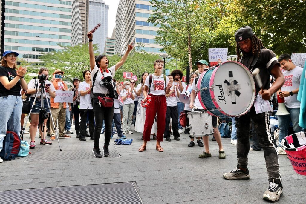 Activists outside City Hall chant and play drums