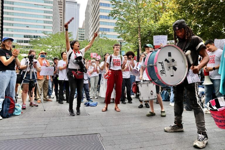 Activists outside Philadelphia City Hall react to Mayor Cherelle Parker’s announcement that she has reached an agreement to build a new Sixers arena in Center City adjacent to Chinatown. (Emma Lee/WHYY)