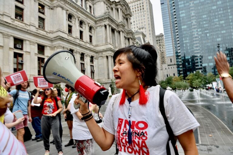 Activists outside Philadelphia City Hall react to Mayor Cherelle Parker’s announcement that she has reached an agreement to build a new Sixers arena in Center City adjacent to Chinatown. (Emma Lee/WHYY)