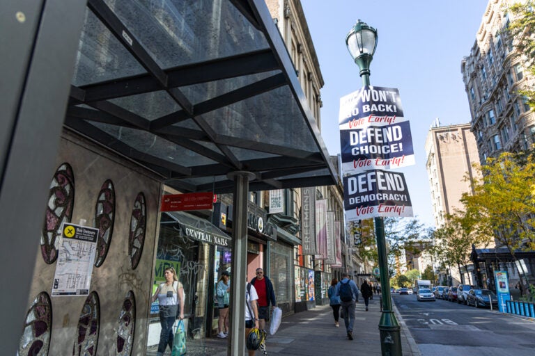 street signs read WE WONT GO BACK! VOTE EARLY! DEFEND CHOICE! VOTE EARLY! and DEFEND DEMOCRACY! VOTE EARLY!