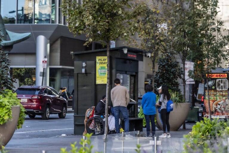 Members of the street medicine team check in on a person in a wheelchair