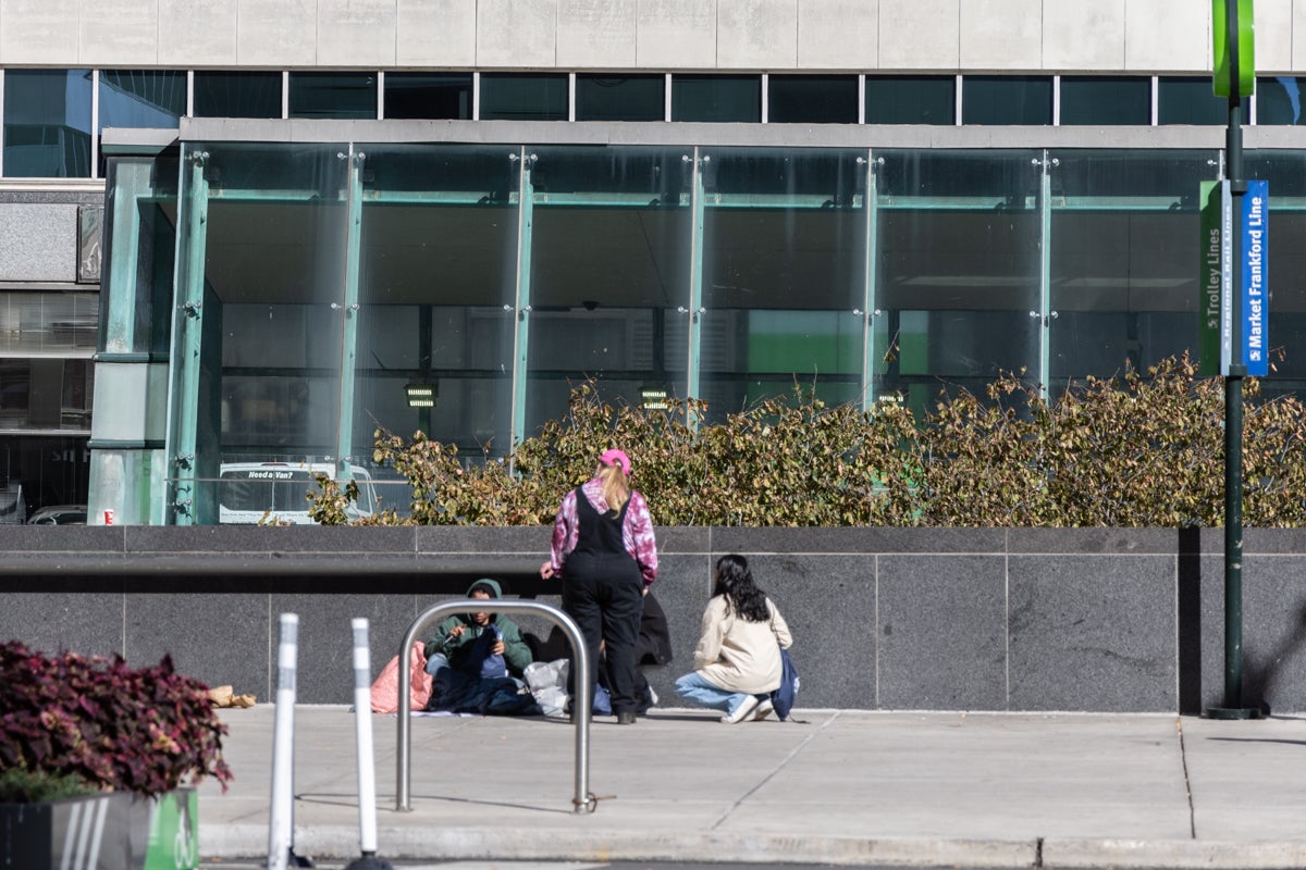 Two team members check in on a person experiencing homelessness