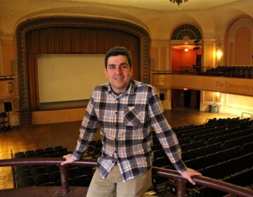 Lightbox Chief Curator Jesse Pires stands in a movie theater