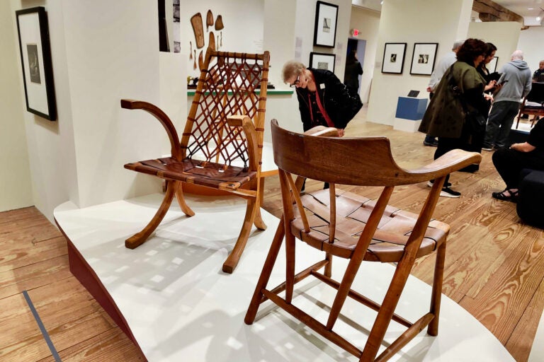 A visitor to the Brandywine Museum investigates two chairs made by Wharton