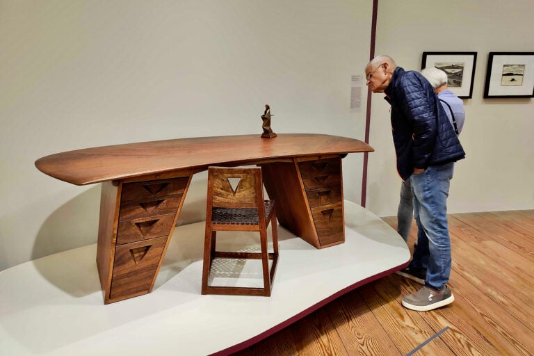 A visitor to the Brandywine Museum investigates Wharton Esherick's Flat Top Desk and Chair