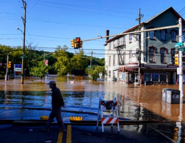 A person walks on a flooded street