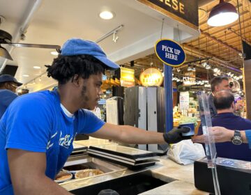 a Bassetts worker hands ice cream to a customer