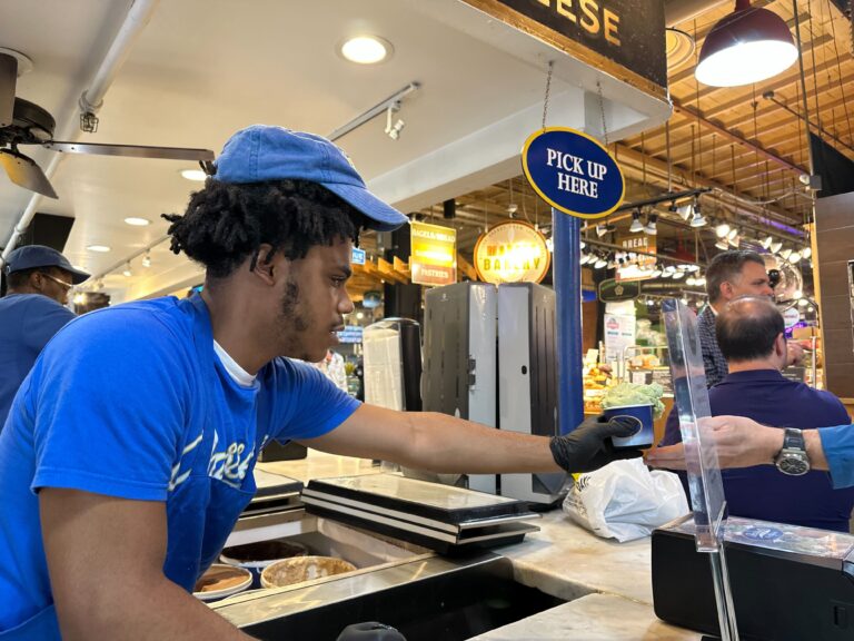 a Bassetts worker hands ice cream to a customer