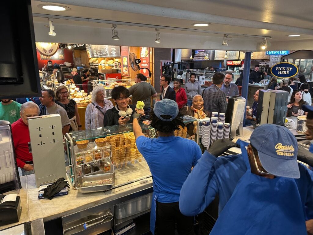 a Bassetts worker hands ice cream to a customer