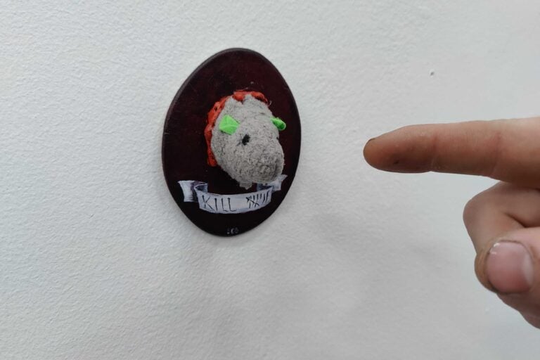 Artist Shawn Beeks beheaded a mouse toy and fixed it to a tiny taxidermy wall mount. (Peter Crimmins/WHYY)