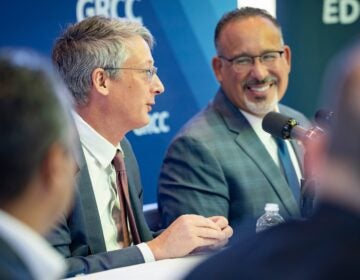 Miguel A. Cardona smiles at James Kvaal