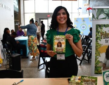 Author Adriana Erin Rivera at a booth