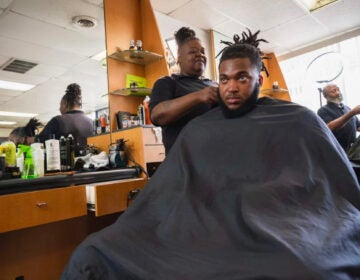 Cherita Evans aka Storm the Barber, with Christian Pounds in her chair at Head Changerz Barber Lounge in Rocky Mount, N.C. on May 23, 2024. (Andrea Ellen Reed/NPR)