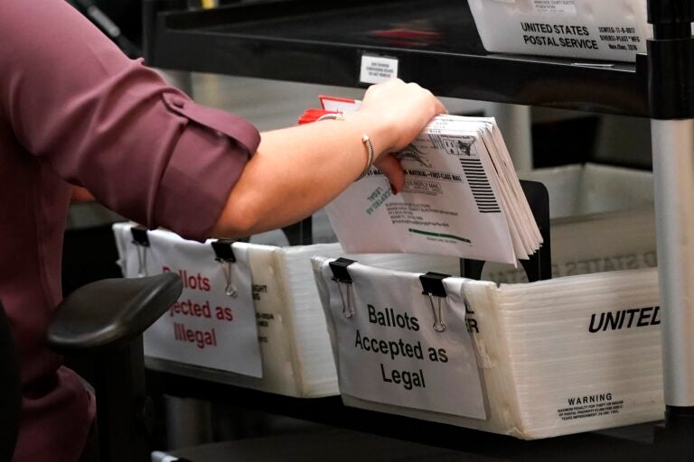 Election worker sorts vote-by-mail ballots