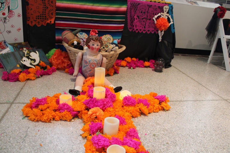 An altar created by Zuhail Corro and Stephanie Placido remembers children who have died, and displays toys, candies and other treats that are popular with children in Mexico. (Emily Neil/WHYY)