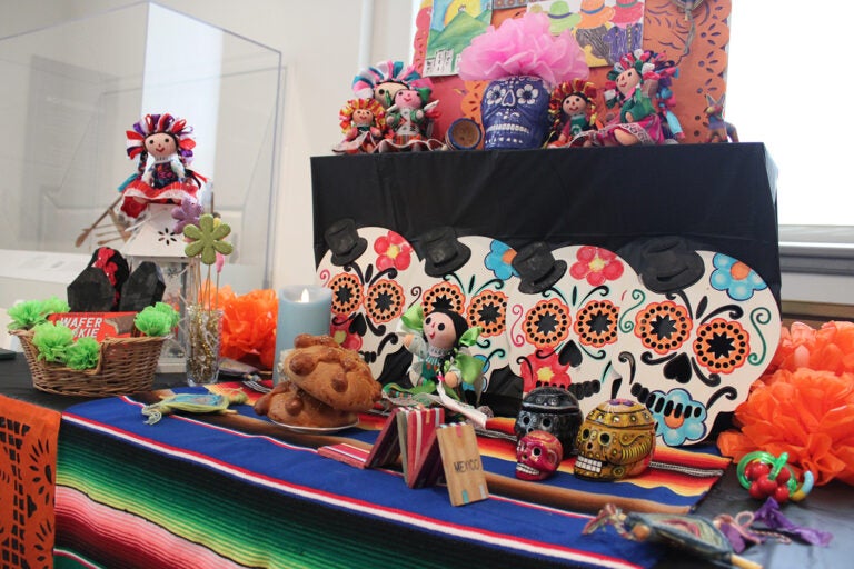 An altar created by Zuhail Corro and Stephanie Placido remembers children who have died, and displays toys, candies, and other treats that are popular with children in Mexico. (Emily Neil/WHYY)