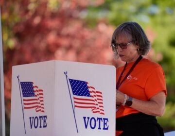 Sally Moore fills out a mail-in ballot application at Montgomery County voter services mobile location in King of Prussia, Pa., Tuesday, Oct. 22, 2024.
