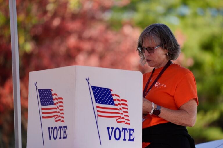 Sally Moore fills out a mail-in ballot application at Montgomery County voter services mobile location in King of Prussia, Pa., Tuesday, Oct. 22, 2024.