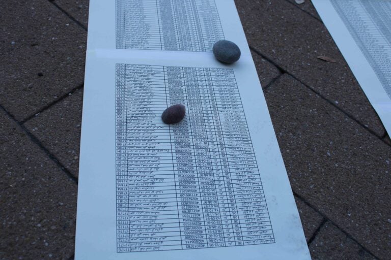 Lists of names of 34,000 Palestinians who have been killed in the conflict were laid on the ground. (Emily Neil/WHYY)