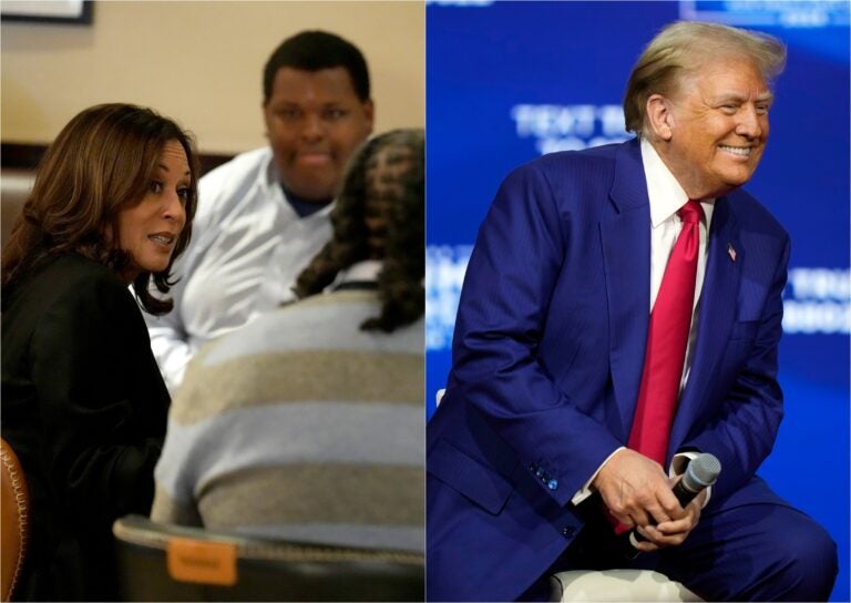 Kamala Harris sits and speaks with others at a table, Trump smiles while holding a microphone