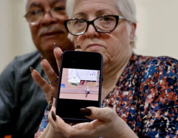 Miriam Saladin, next to her husband, shows a photo from her phone