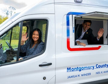 Commissioners Jamila Winder, left, and Neil Makhija, right, pose with Montgomery County's new voter services van.