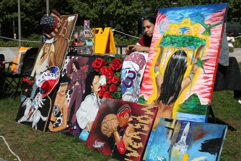 mural-arts-festival-2024-10-06-10 an artist selling multiple painting