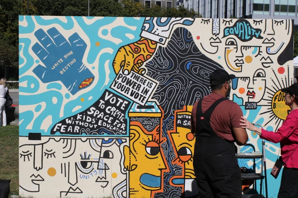 two artists working on a mural