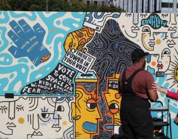 two artists working on a mural