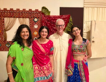 A family dressed in traditional Hindu garb pose for a photo