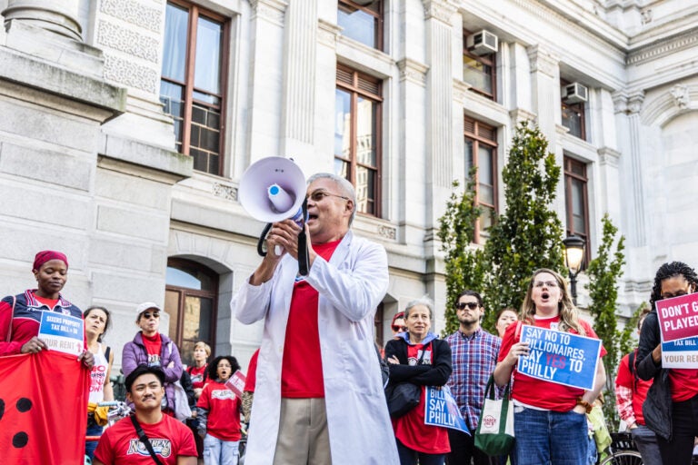 Dr. Walter Tsou speaks into a megaphone in front of protesters