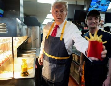 Donald Trump hands a customer fries