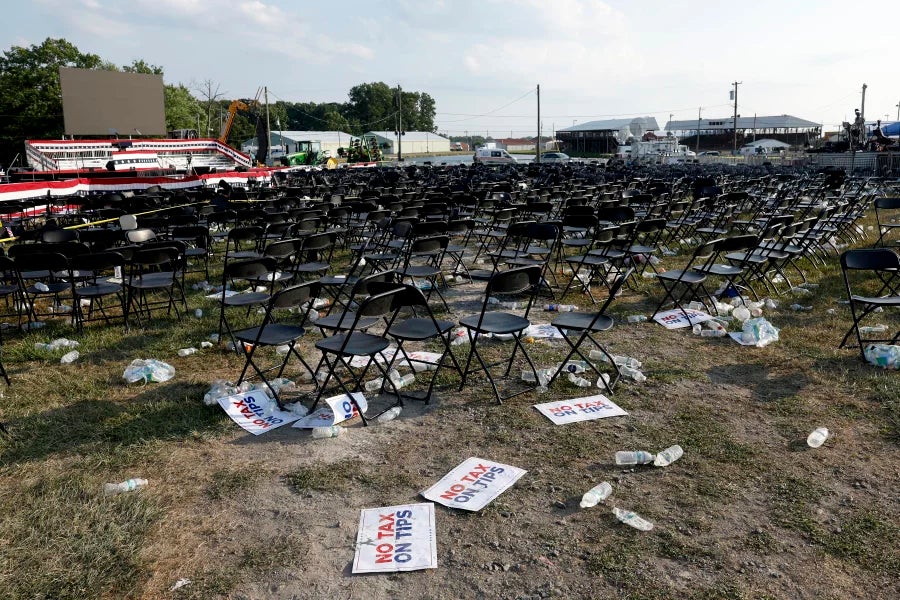 Signs, bottles and other garbage lie on the grass beneath seats following a political rally for Republican presidential candidate Donald Trump