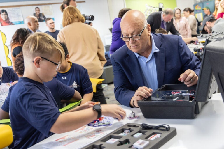 Cal Ripken Jr., baseball Hall of Fame shortstop, helps a Tinicum School student with a STEM activity at the school’s new STEM center, donated by the Cal Ripken Sr. Foundation on November 20, 2024. (Kimberly Paynter/WHYY)