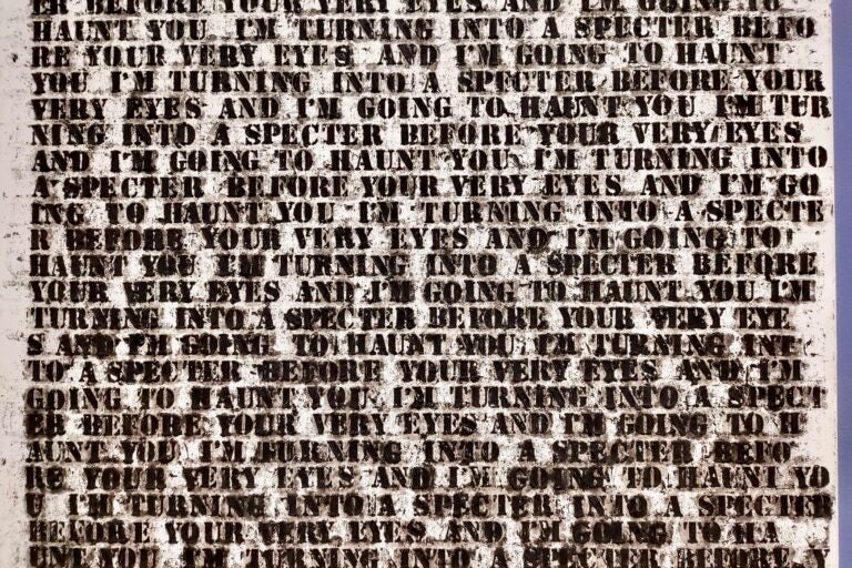 A detail of Glenn Lligon's ''Untitled'' (1992), in which he repeats the phrase ''I'm turning into a specter before your very eyes and I'm going to haunt you'' over and over in increasingly blurred and disintegrated text until it becomes undecipherable. (Peter Crimmins/WHYY)