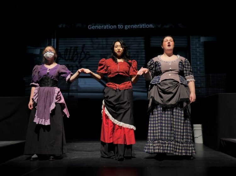 Three versions of Alice Tierney, portrayed by (from left) by Niamh Kelly, HaYoung Nam, and Anastasia Groden, perform on stage at West Chester University's Asplundh Concert Hall during a rehearsal for Melissa Dunphy's opera about the 19th century murder of a sex worker in Philadelphia. (Emma Lee/WHYY)