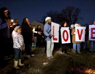 Lawnside residents look on and four signs read LOVE