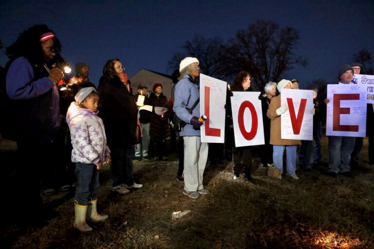 Lawnside residents look on and four signs read LOVE