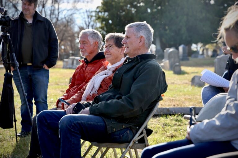 The living descendants of Mathew and Keziah Cornelius, who died in their 30s at the end of the 18th century, and Benjamin Britton, a baker who died in 1782, attend a memorial service after the reburial at Mount Moriah Cemetery. Pictured is George Cornelius (right) of Helena, Montana, and Kathryn Hartmann (center) of Huntington Beach, California. (Emma Lee/WHYY)