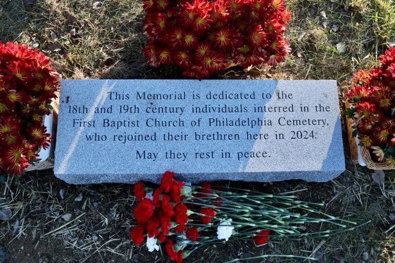 A stone marks the site where human remains unearthed during a construction project in Old City Philadelphia were relocated in Mount Moriah Cemetery. (Emma Lee/WHYY)