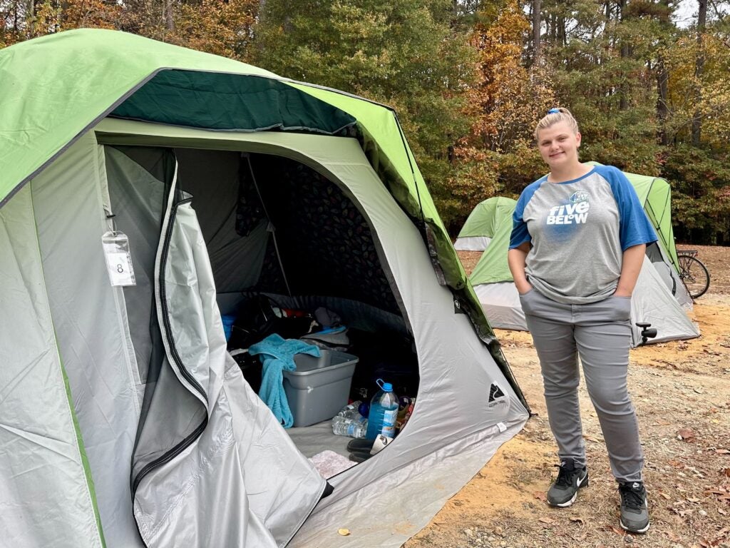 Ashley Heffentrager smiles by a tent